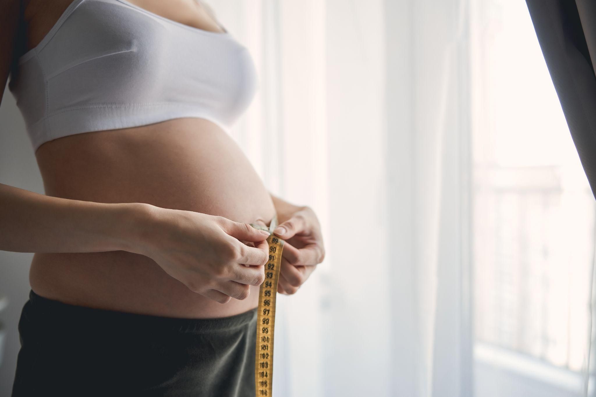 A pregnant woman monitoring the size of her bump during her antenatal journey.