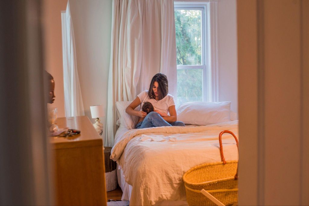 Midwife assisting with a home birth in a calm, supportive environment.