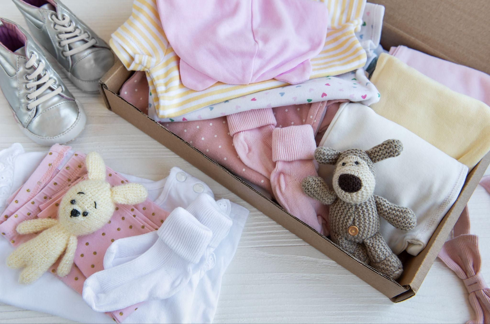 A Baby Box filled with clothes, a cuddly toy, and other newborn essentials.