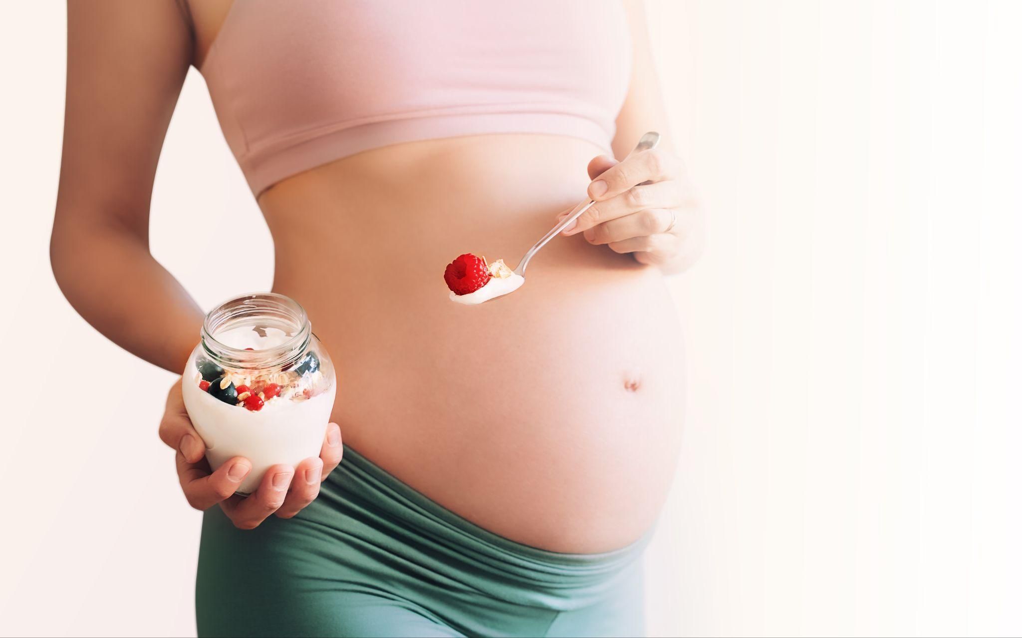 A variety of pregnancy-safe snacks including fruits, yogurt, and nuts.