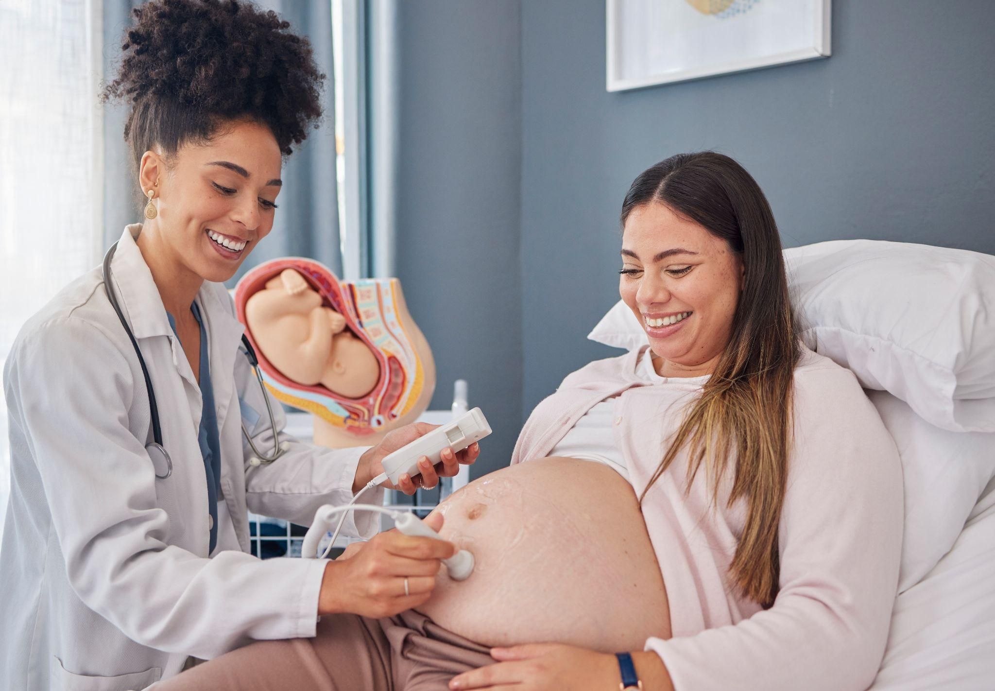 A serene pregnant woman is scanned at an antenatal appointment.