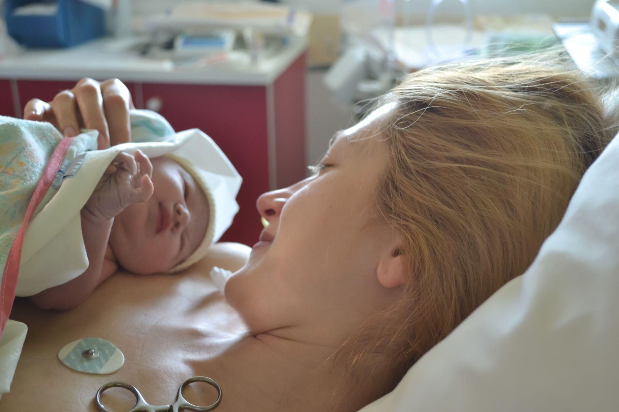 A pregnant woman at an antenatal clinic discussing birth options with her midwife.