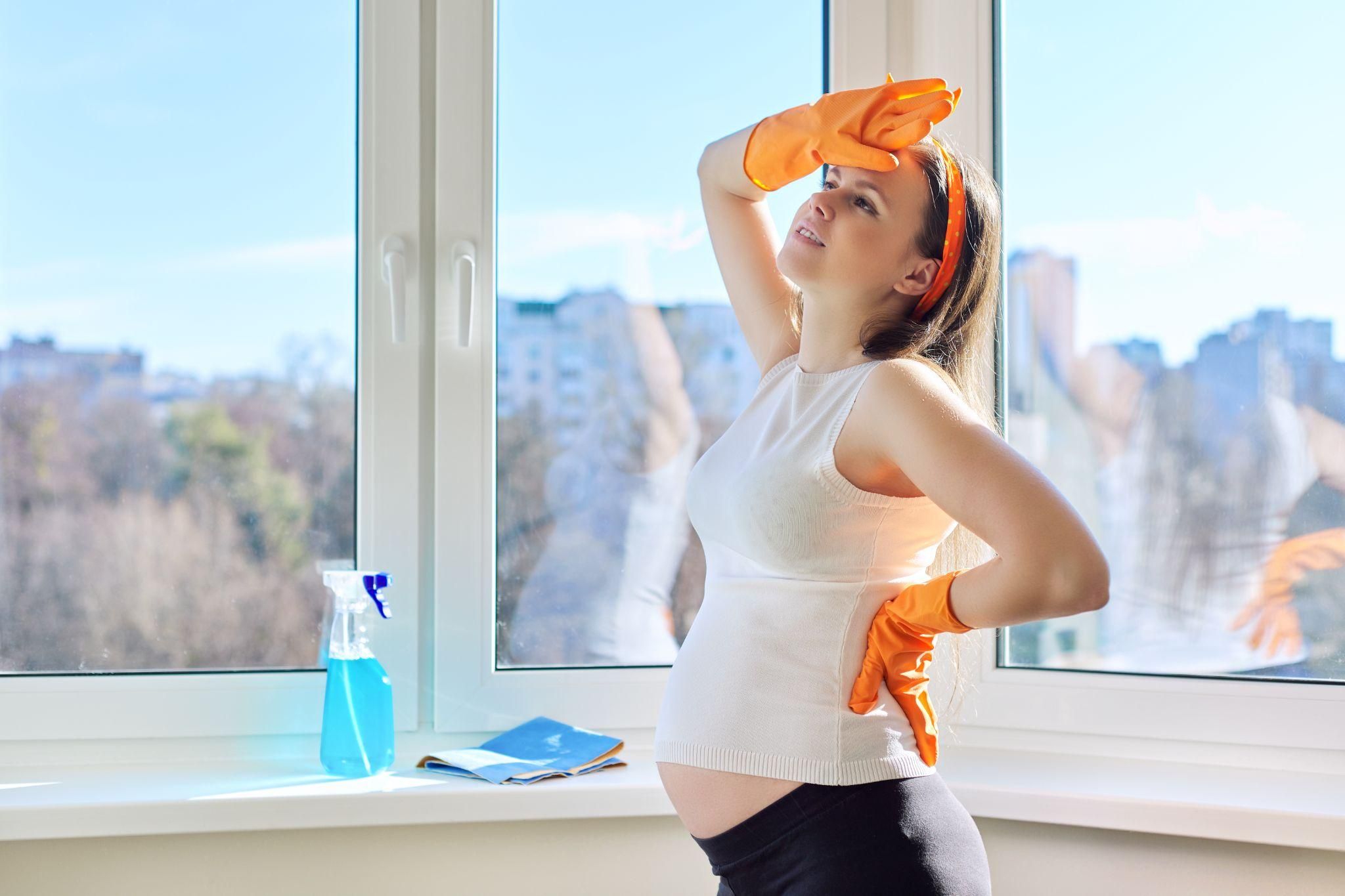 Pregnant woman feeling warm and fanning herself.