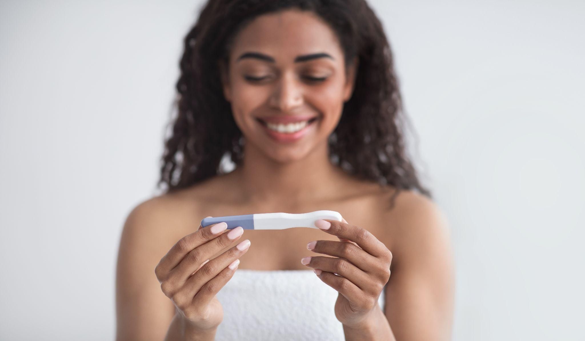 A happy expectant mother noticing early pregnancy signs.