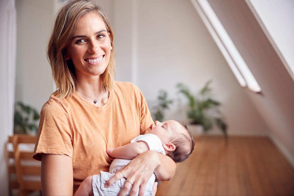 A confident new mum holding her newborn.