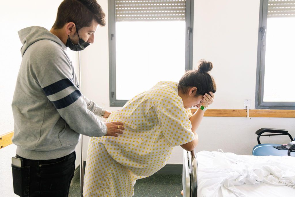 A woman in labour experiencing contractions with support from her partner.