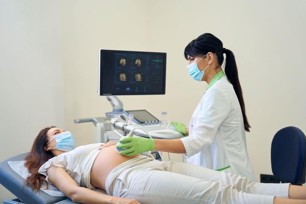 Woman has ultrasound scan during pregnancy at antenatal appointment with obstetrician.