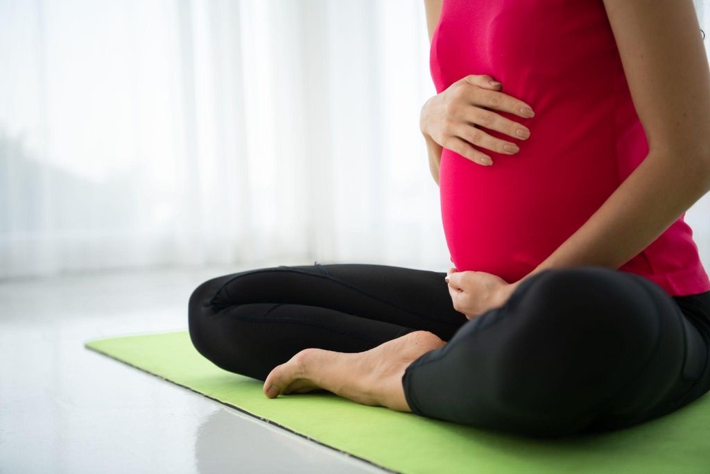 Pregnant woman doing prenatal yoga to strengthen her core muscles and manage diastasis recti.