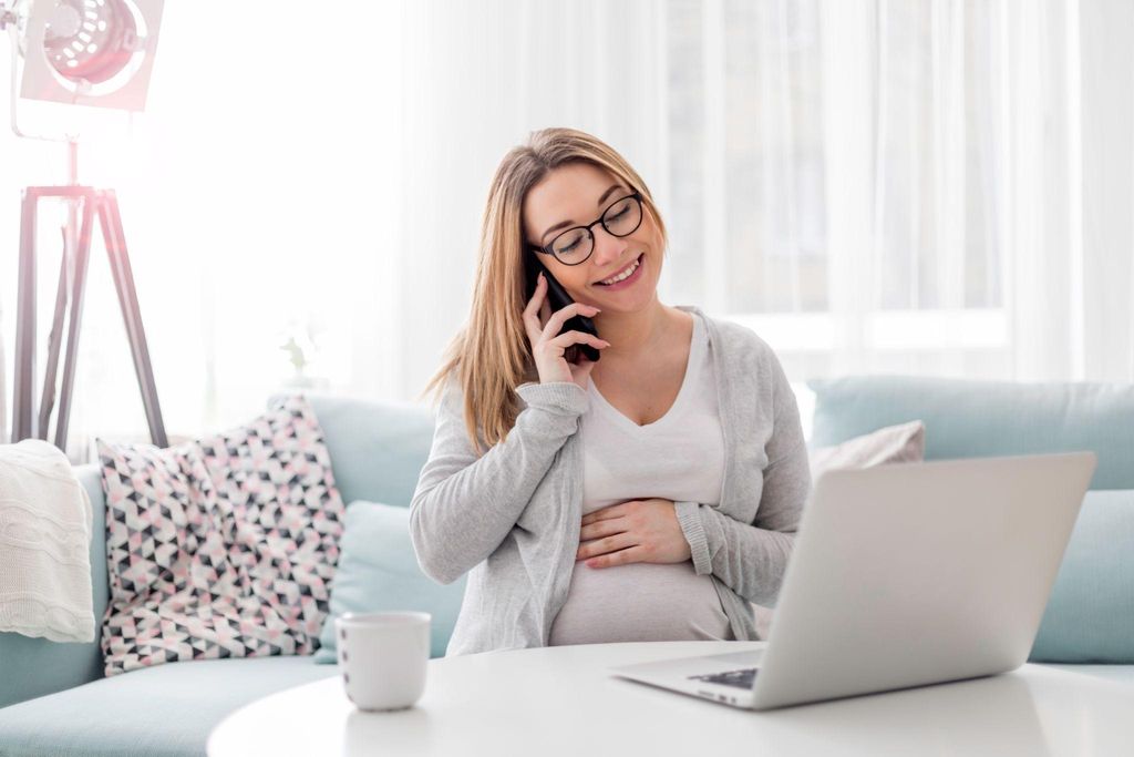 A pregnant woman confidently navigating the antenatal self-referral process online.