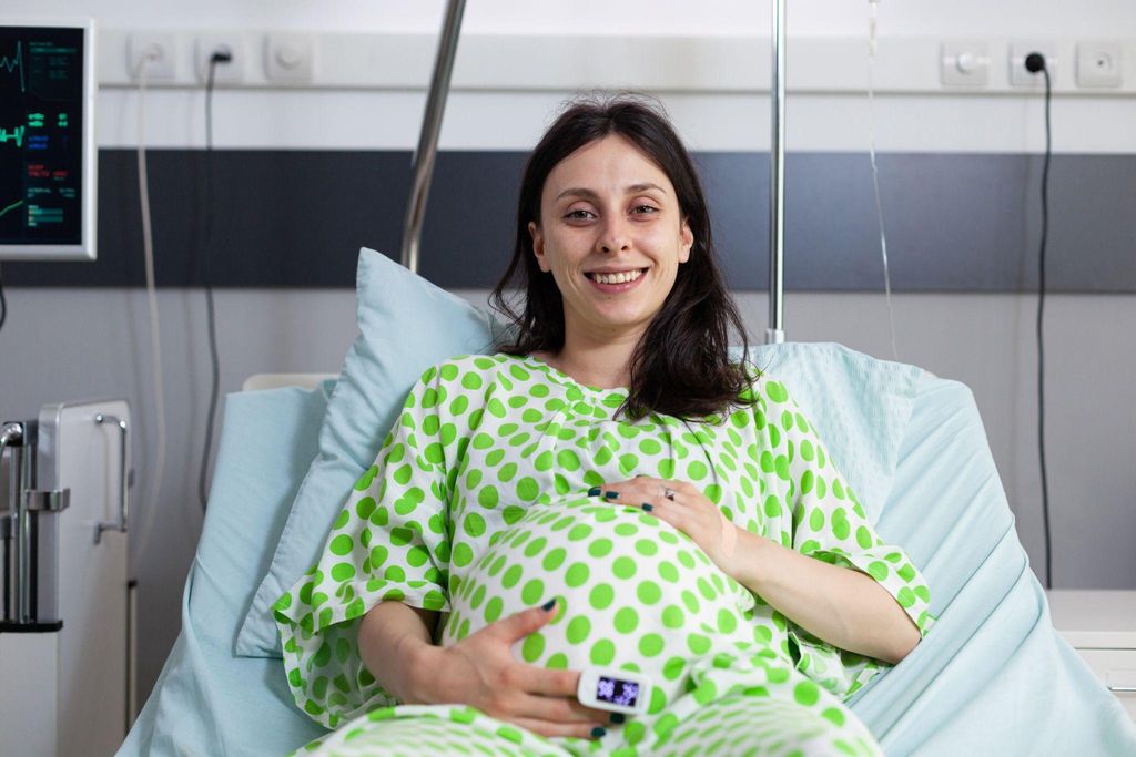 Pregnant woman performing perineal massage to prepare for childbirth, a common practice in antenatal care.