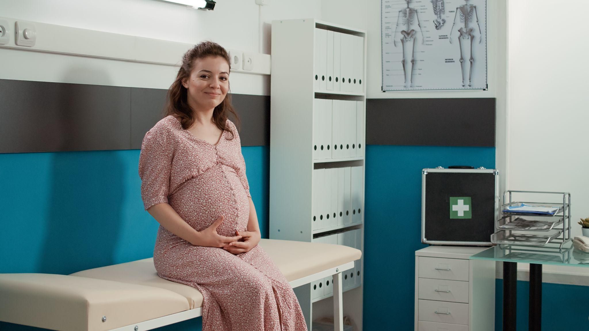 A happy expectant mother with NHS antenatal resources.