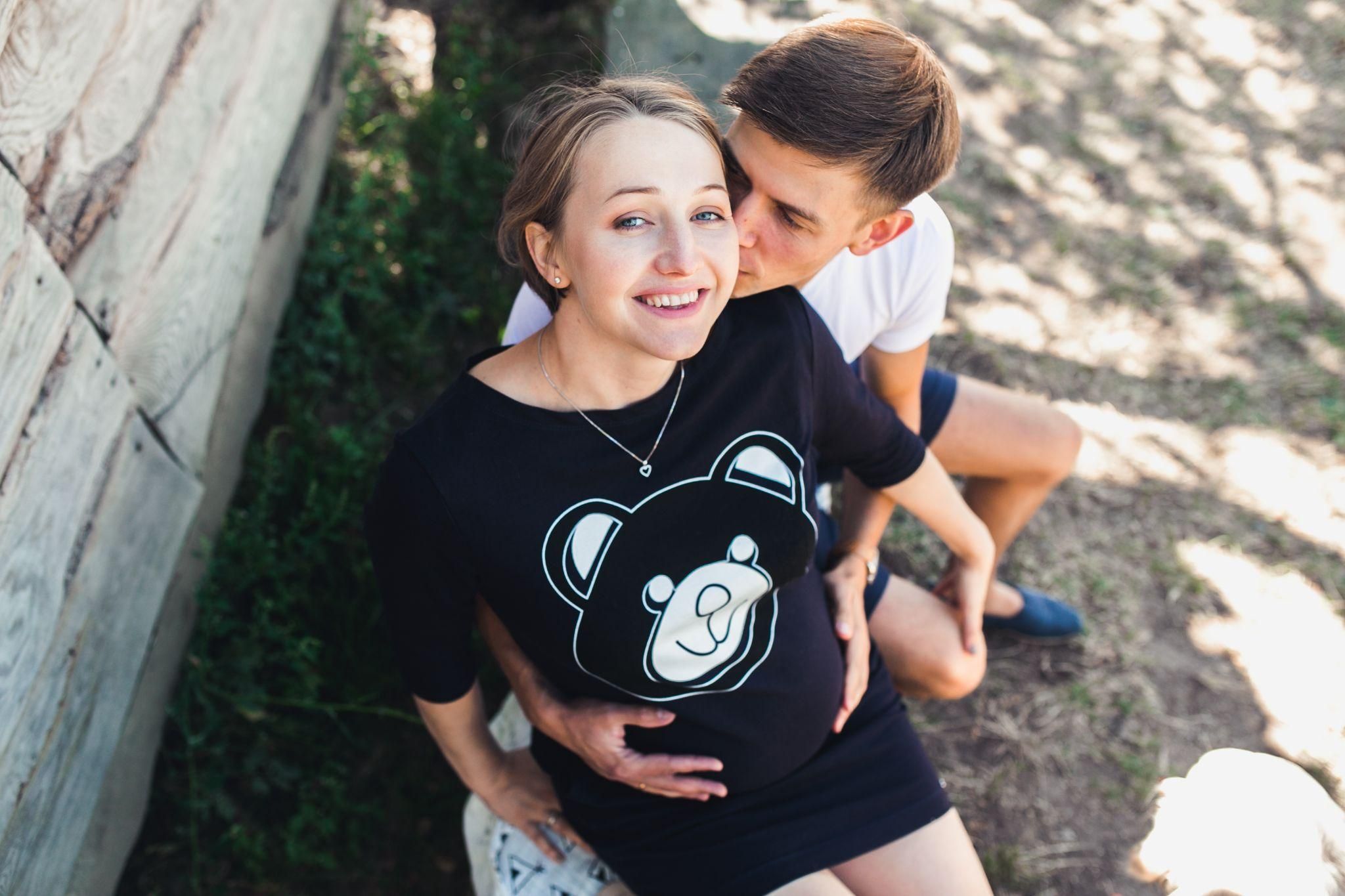 Husband kisses pregnant wife’s cheek.