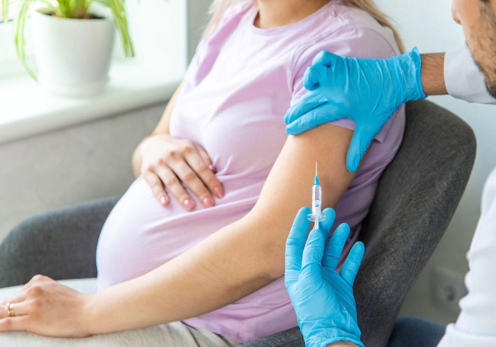 A healthcare provider administering a vaccine to a pregnant woman.