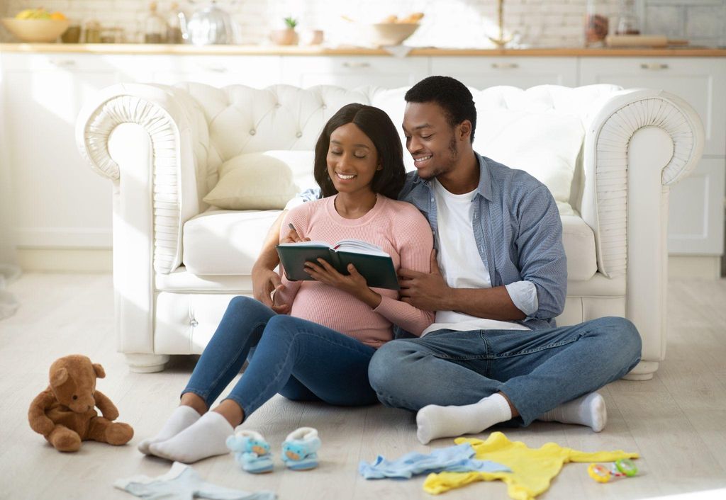 Expectant mother reading an antenatal book while sitting in a bright room.