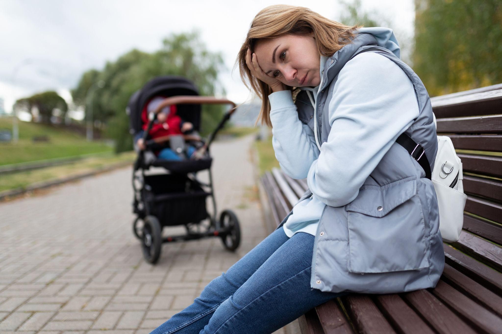 A thoughtful new parent holding their baby and reflecting on the challenges of early parenthood.