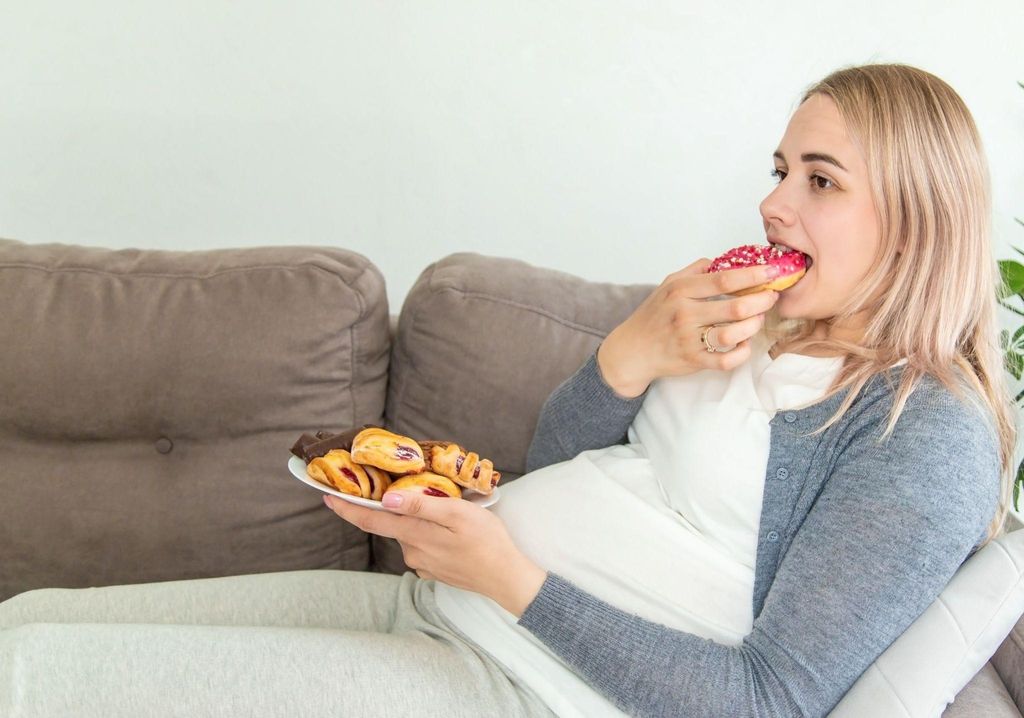 A pregnant woman eating a salad to support her baby's health.