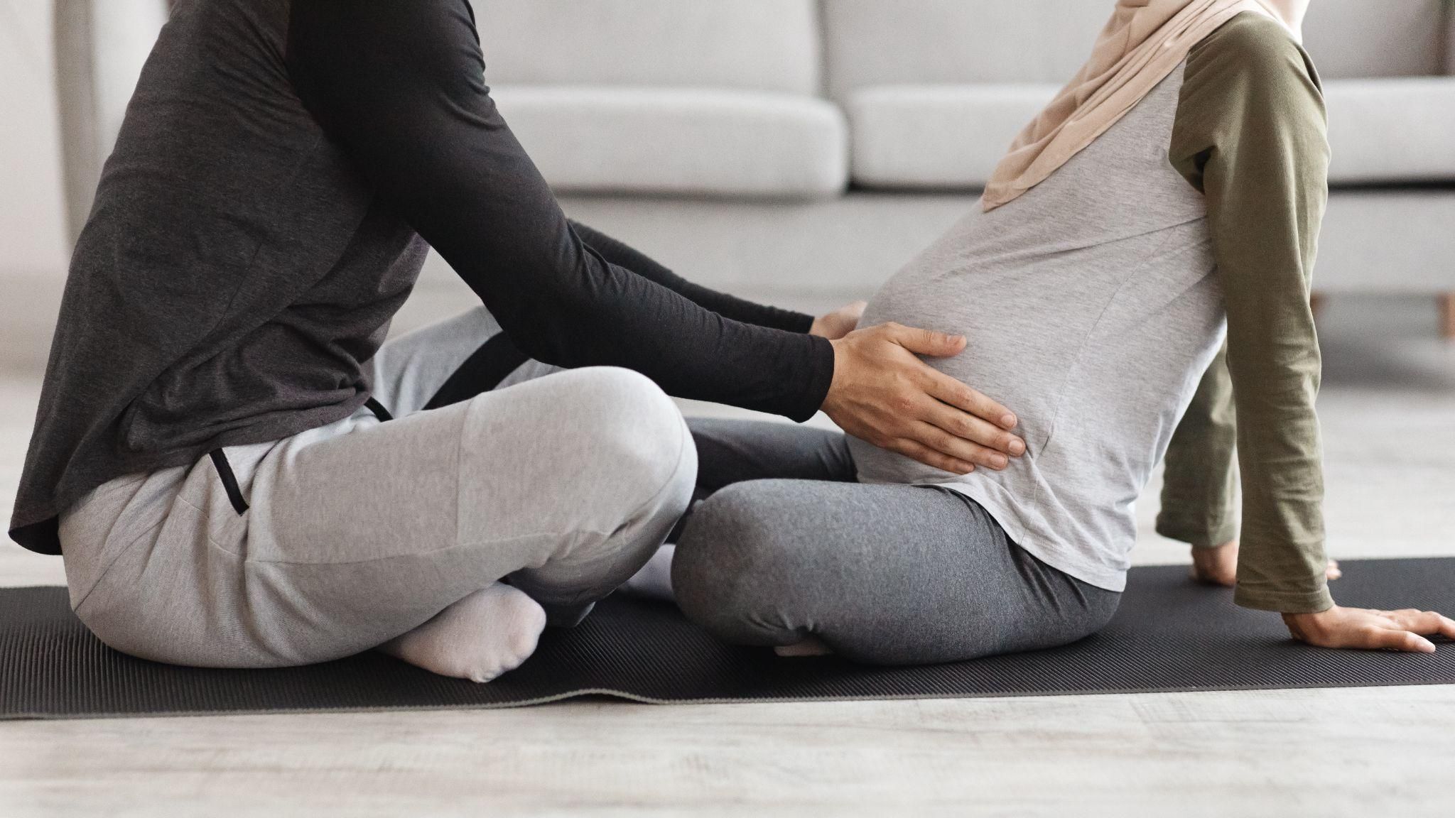 Expectant parents sitting in a classroom, learning about childbirth during an antenatal class.