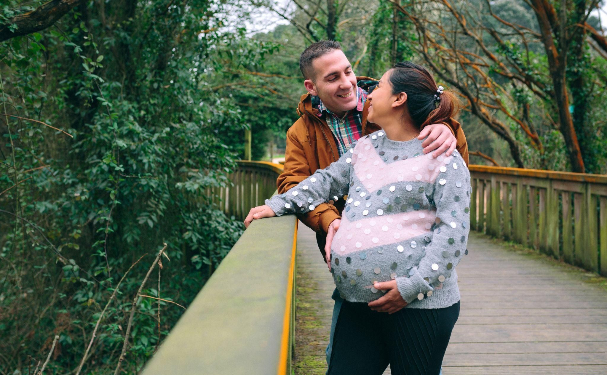 Pregnant woman discussing financial concerns with a partner, exploring options for antenatal care and baby essentials.