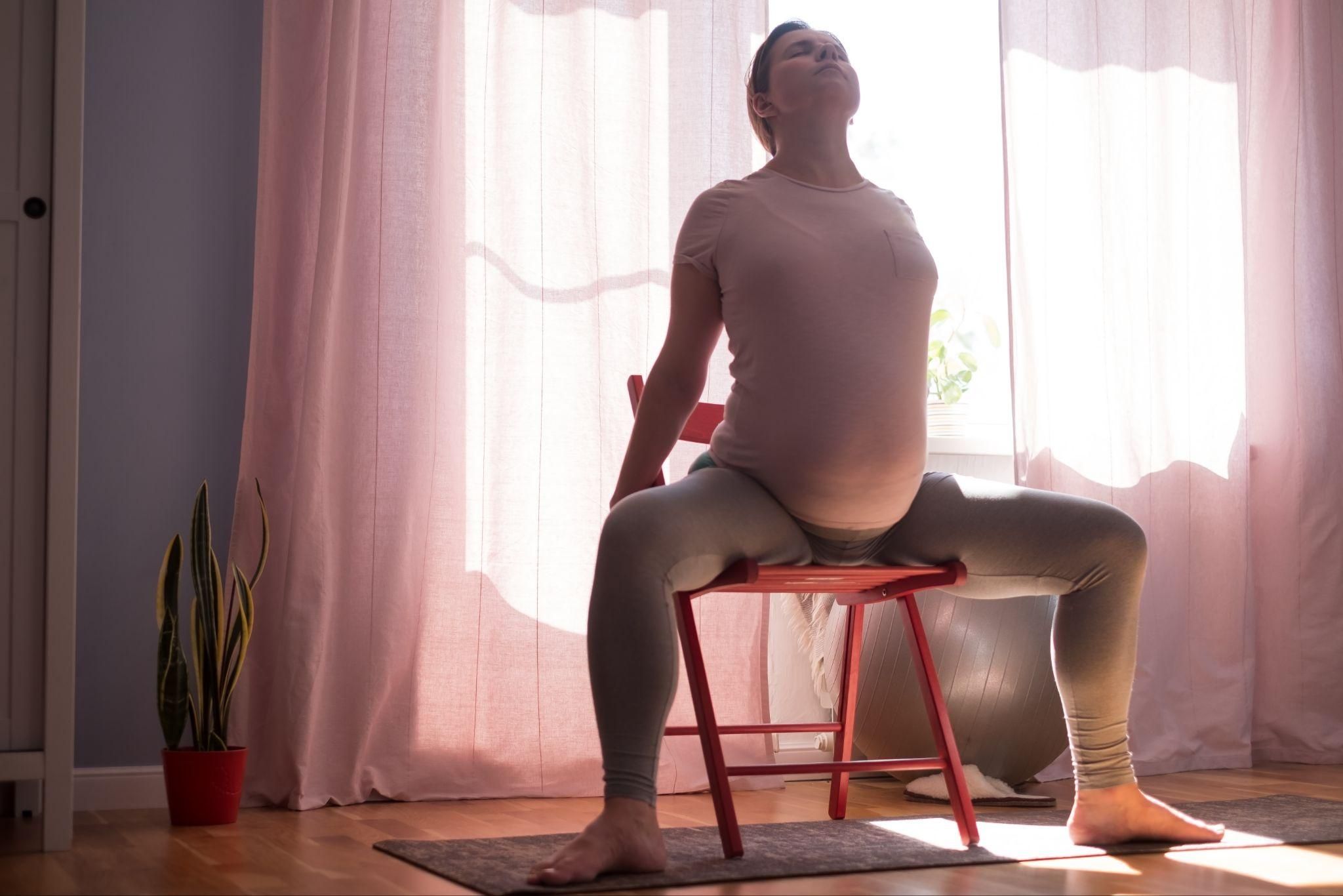 Pregnant woman performing prenatal yoga to relieve round ligament pain.