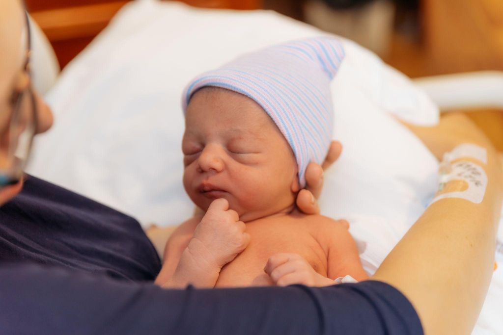 Mother holds newborn baby in her arms.