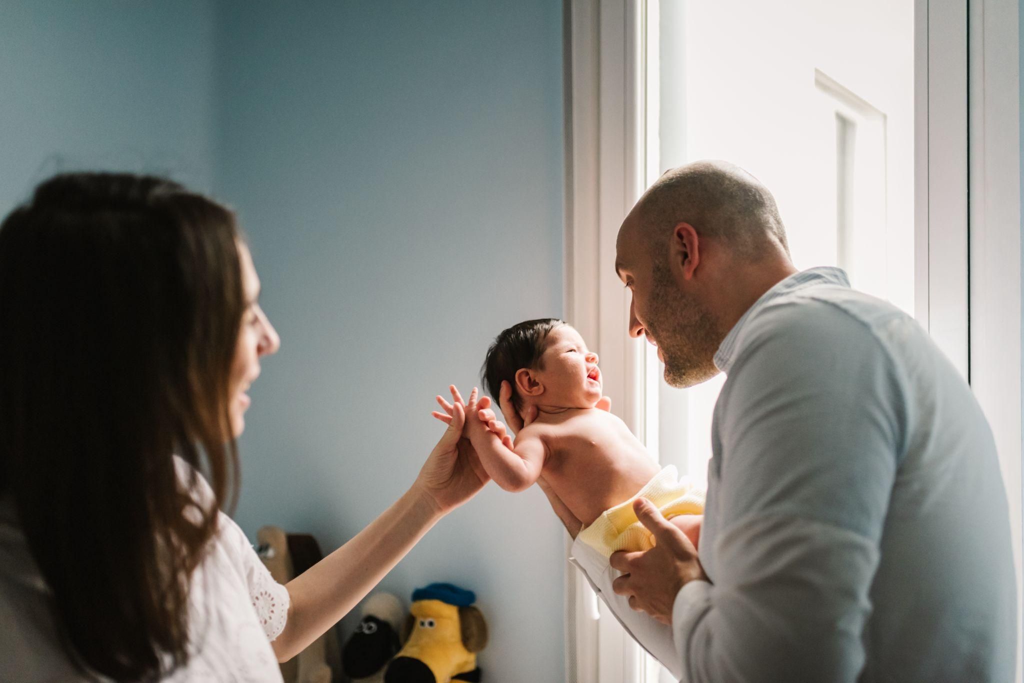 New parents talking to baby in nursery.