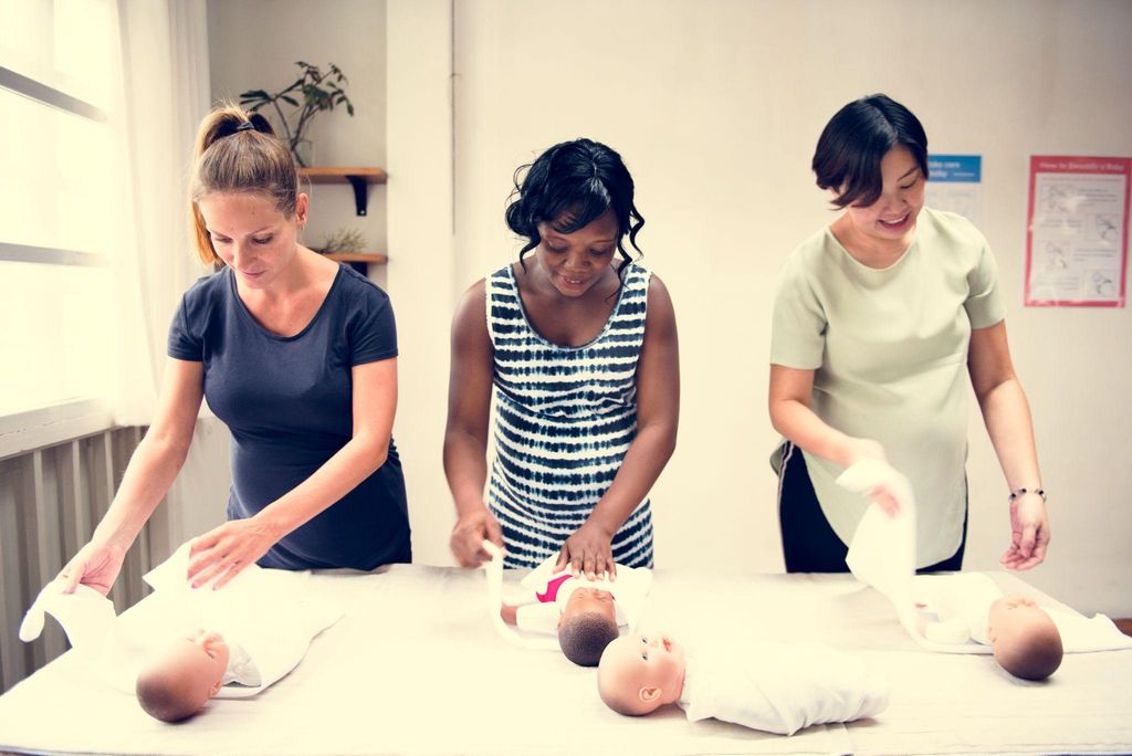 A couple learning baby care techniques during an antenatal session.