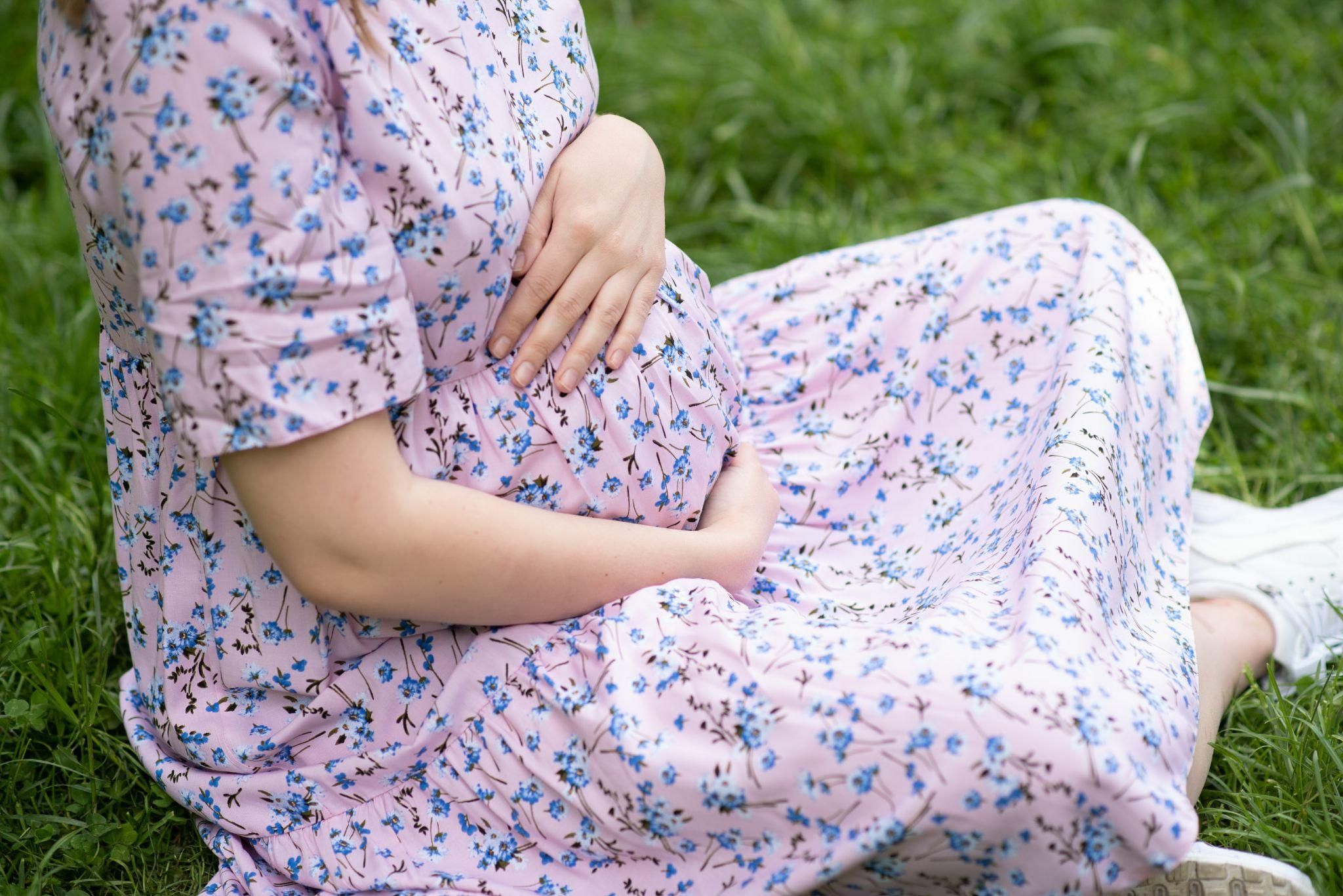 A pregnant woman sitting comfortably, practising antenatal yoga to alleviate cramps and support relaxation.