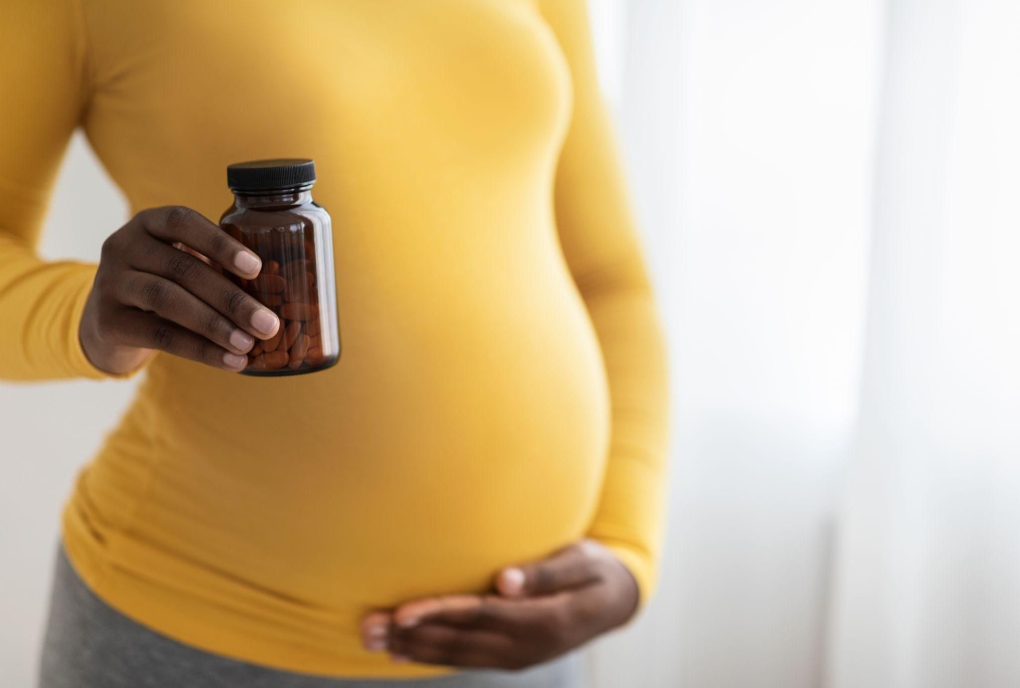 Pregnant person taking collagen supplements as part of their antenatal care.