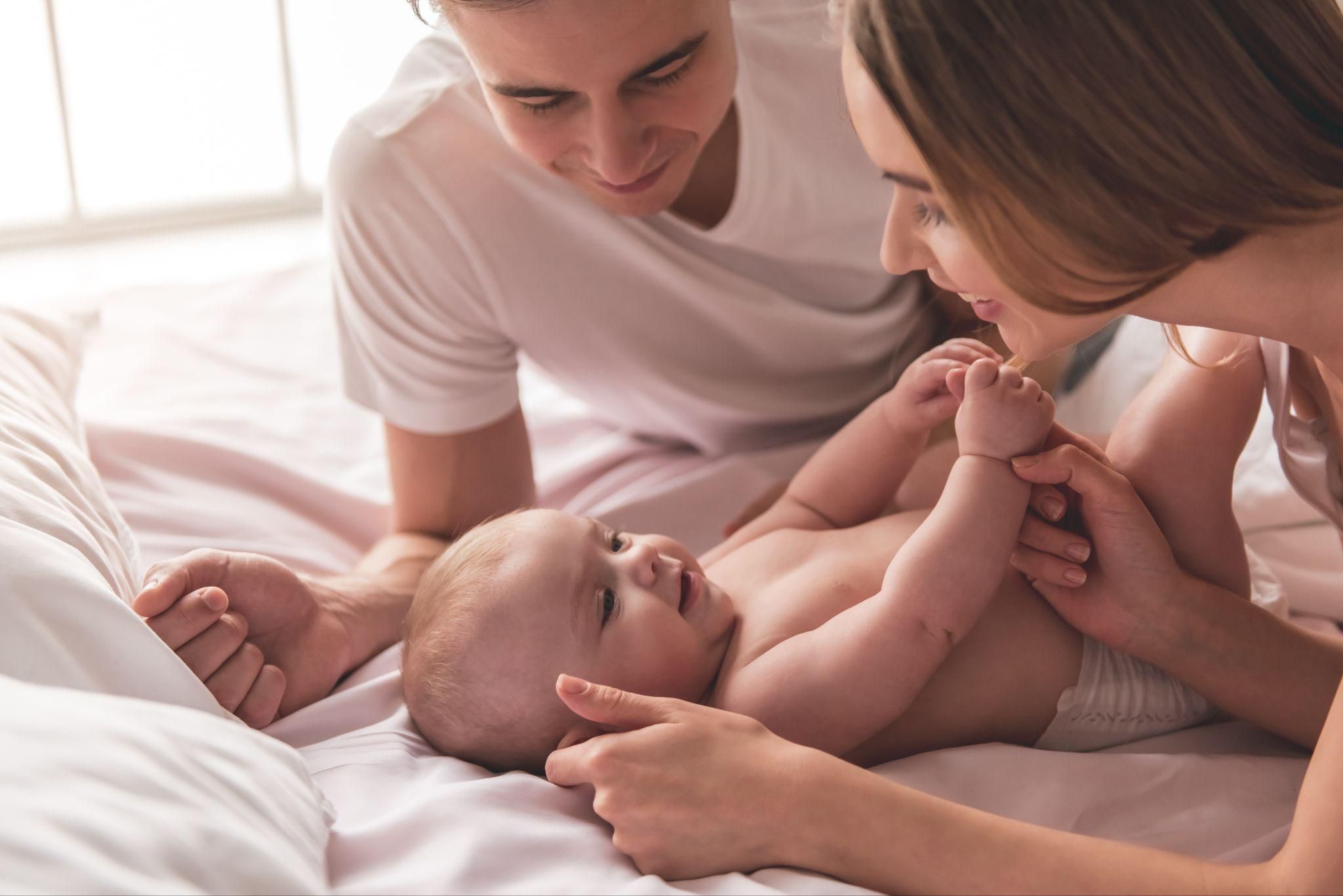 A happy couple bonding with their baby at home.