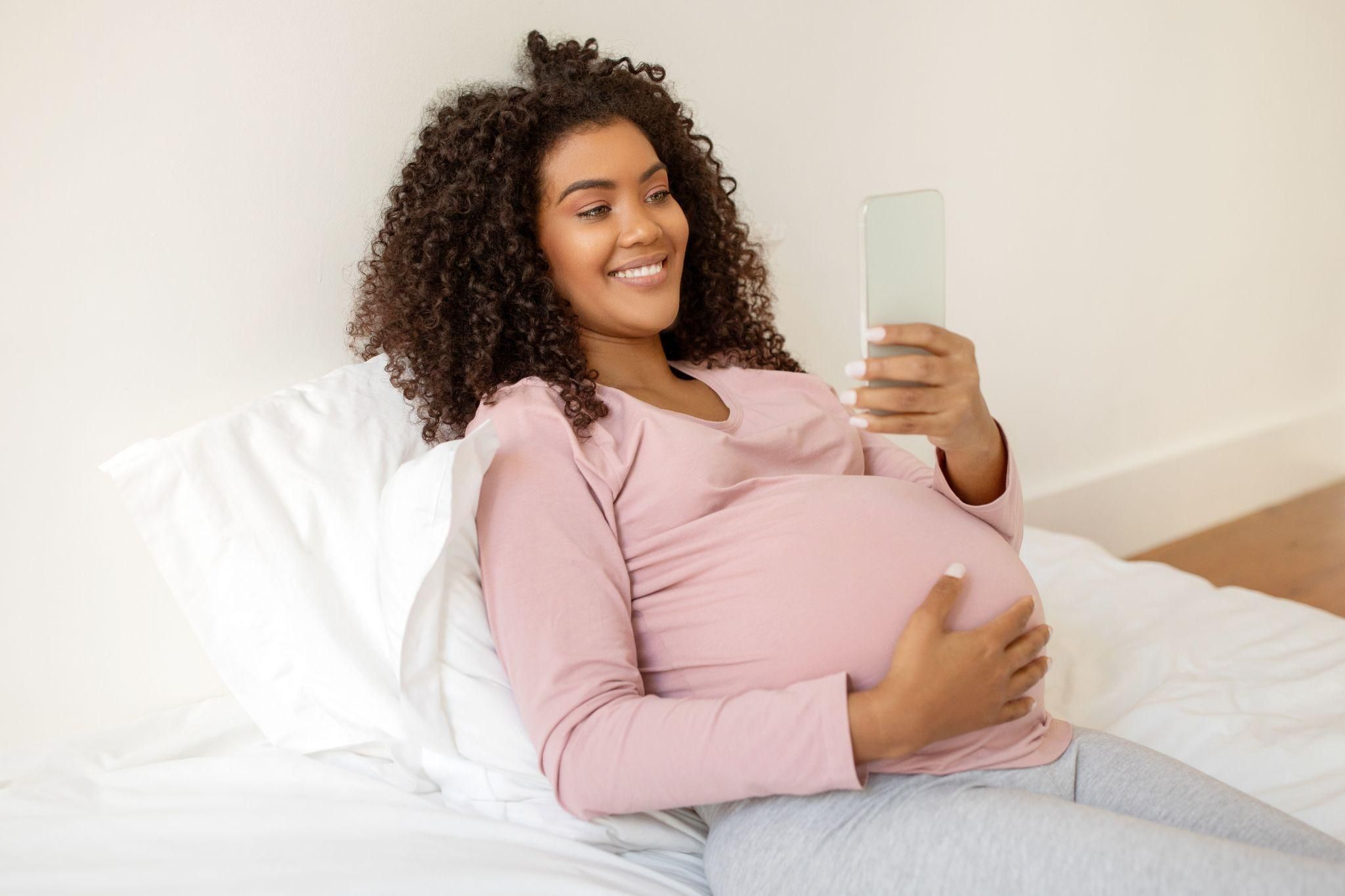 Pregnant influencer taking selfie.