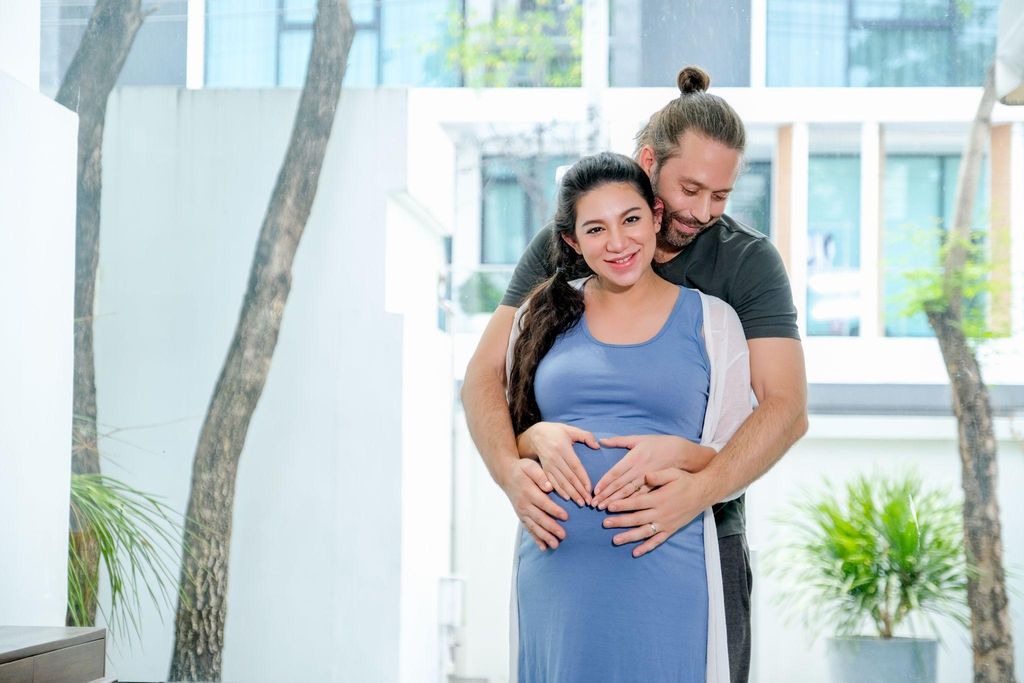 Expectant mother smiling as she reflects on her journey toward motherhood.