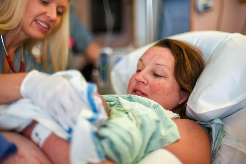 A mother navigating unexpected changes during childbirth, with the guidance of a midwife.