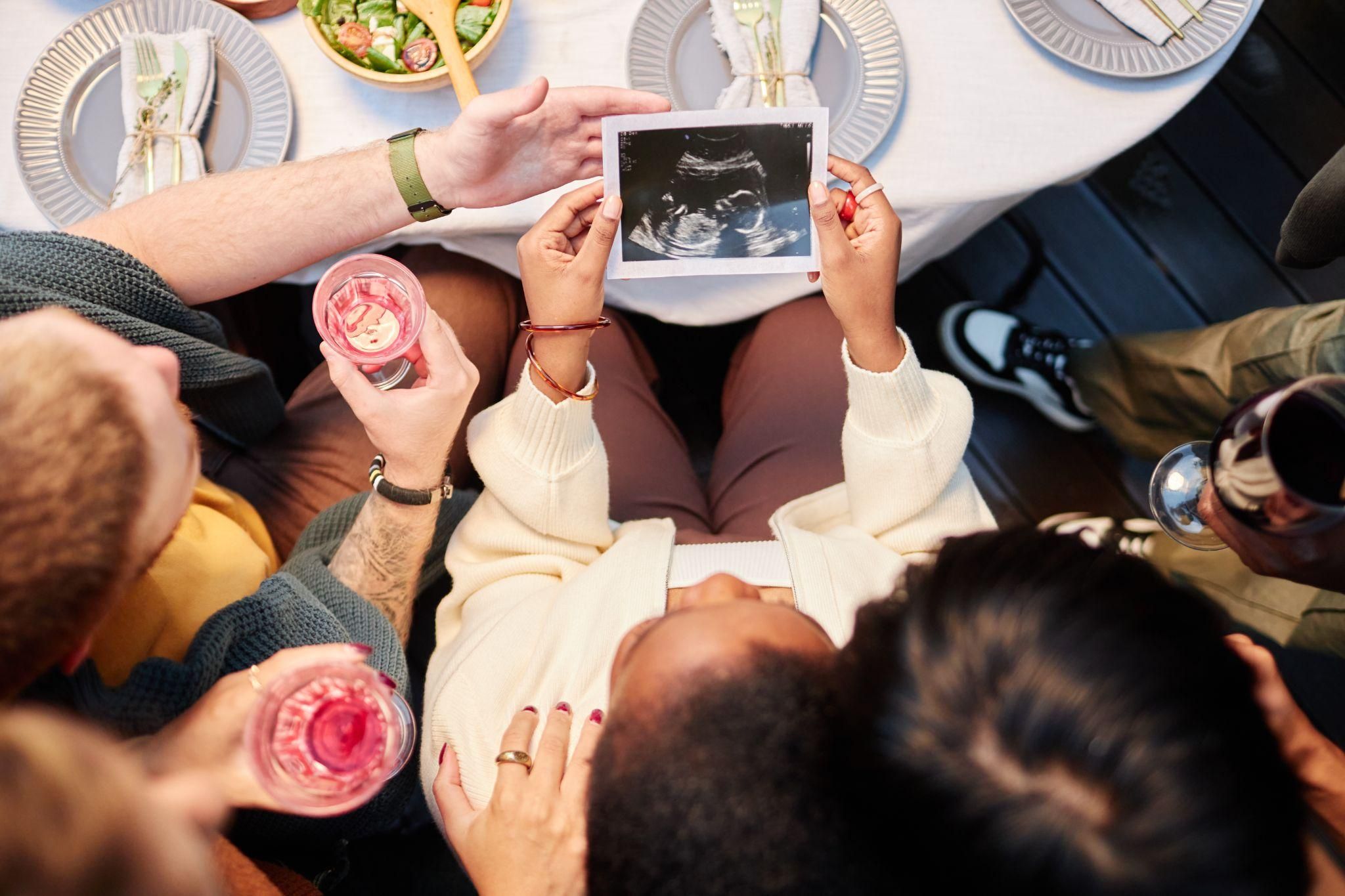 A group of women laughing and playing games at a baby shower.