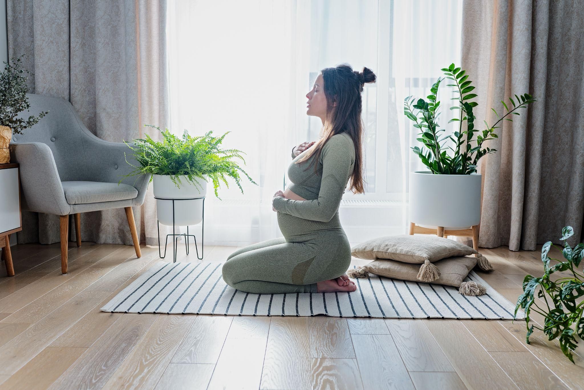 Pregnant woman practising antenatal yoga to relax and prepare for labour at 41 weeks pregnant.