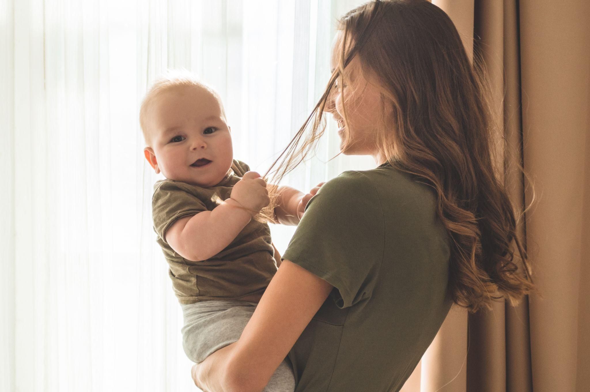 A mother caring for her postpartum hair while managing new motherhood.