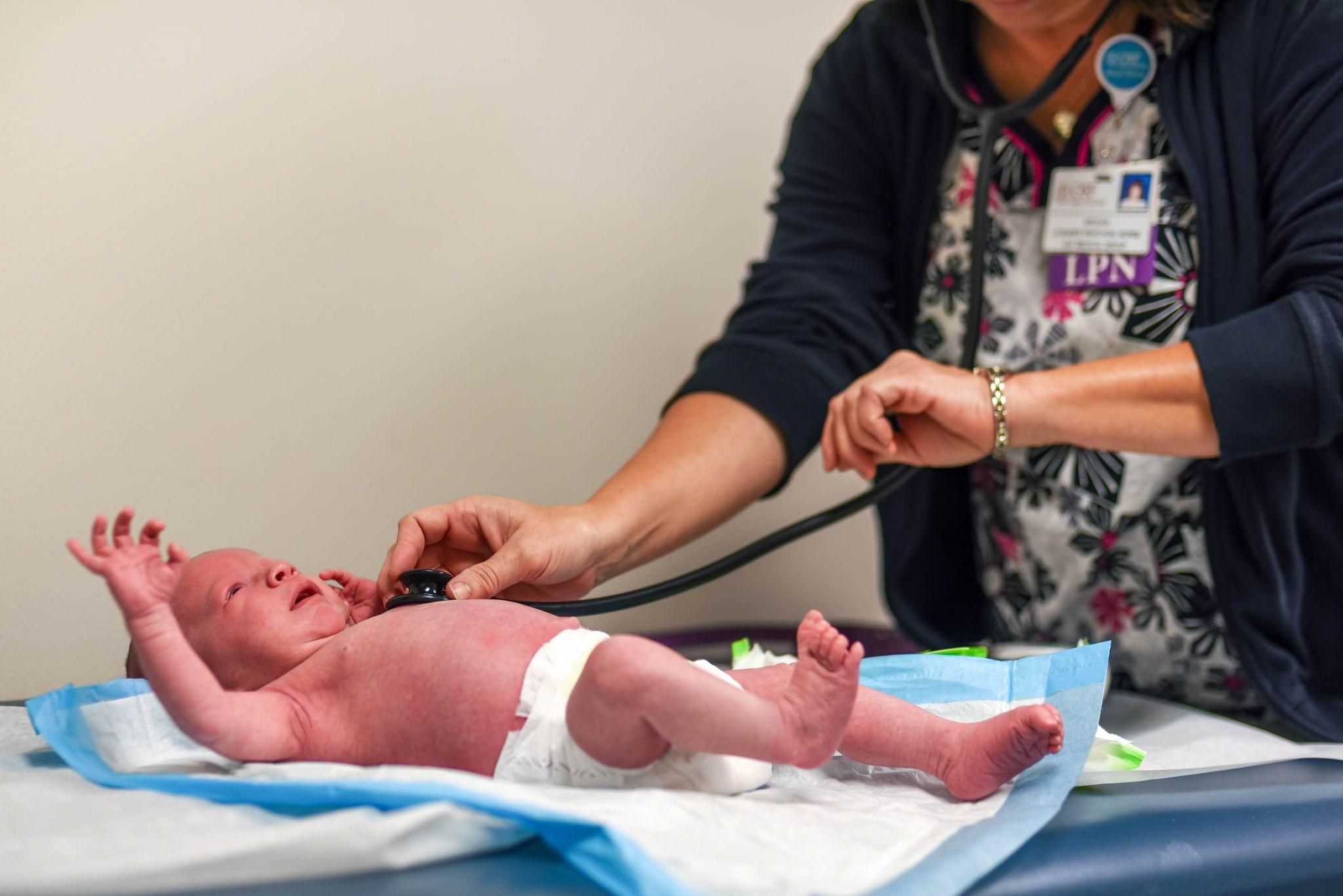 A healthcare professional examines a newborn after childbirth.