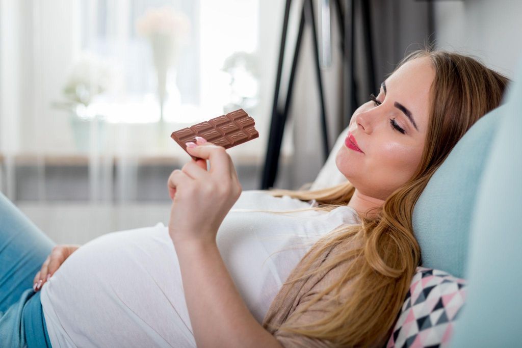 Pregnant woman eating chocolate.