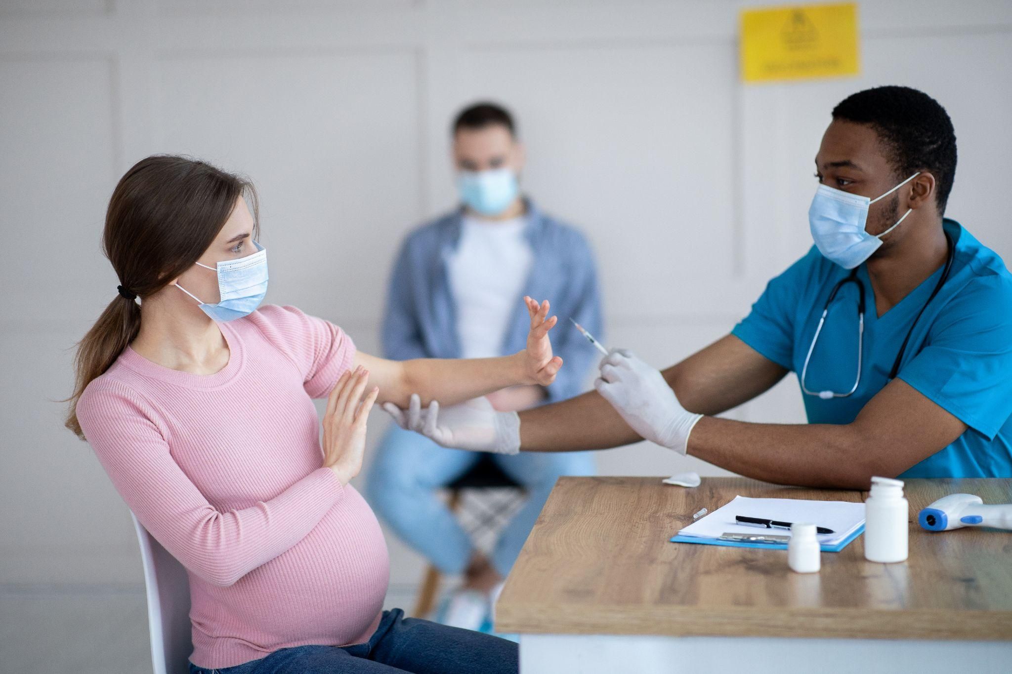 A pregnant woman discussing vaccination options with her healthcare provider.