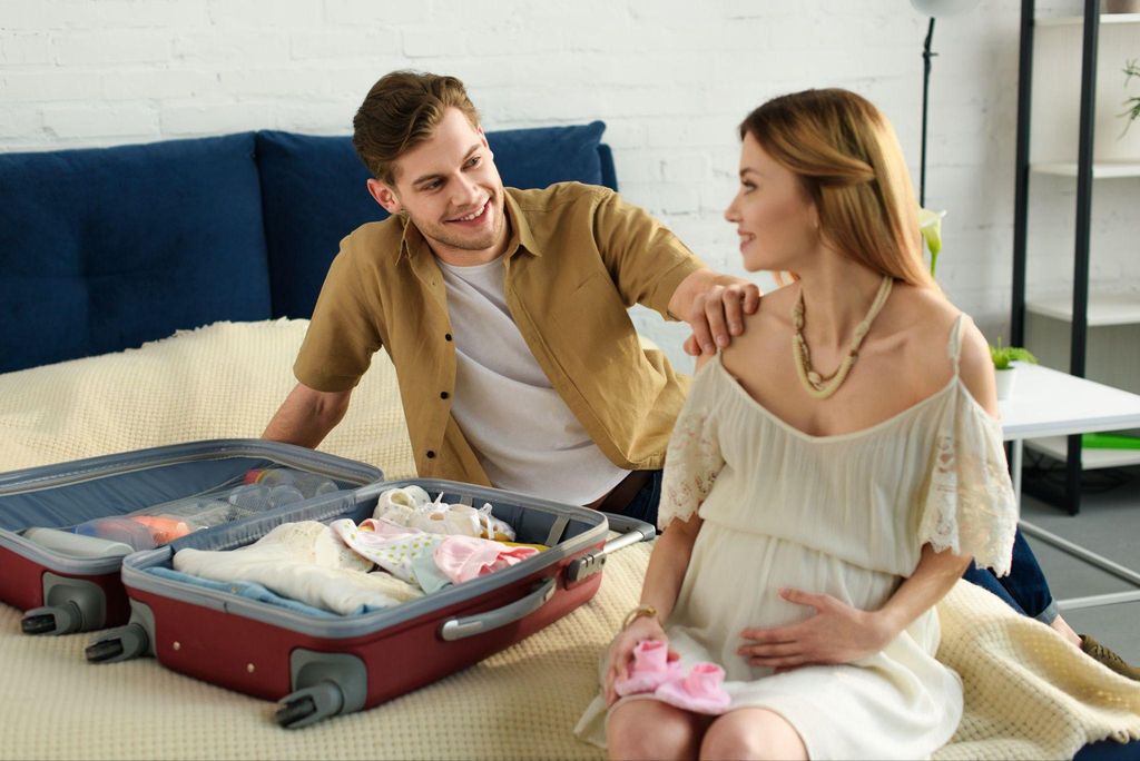 A pregnant woman reviewing her hospital bag with her partner as part of antenatal preparation.