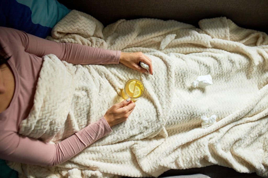 A pregnant woman in a clinic handing over a urine sample to a nurse.