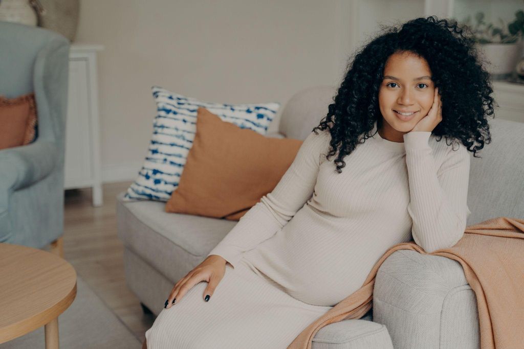 A happy expectant mother receiving guidance at an NHS antenatal appointment.