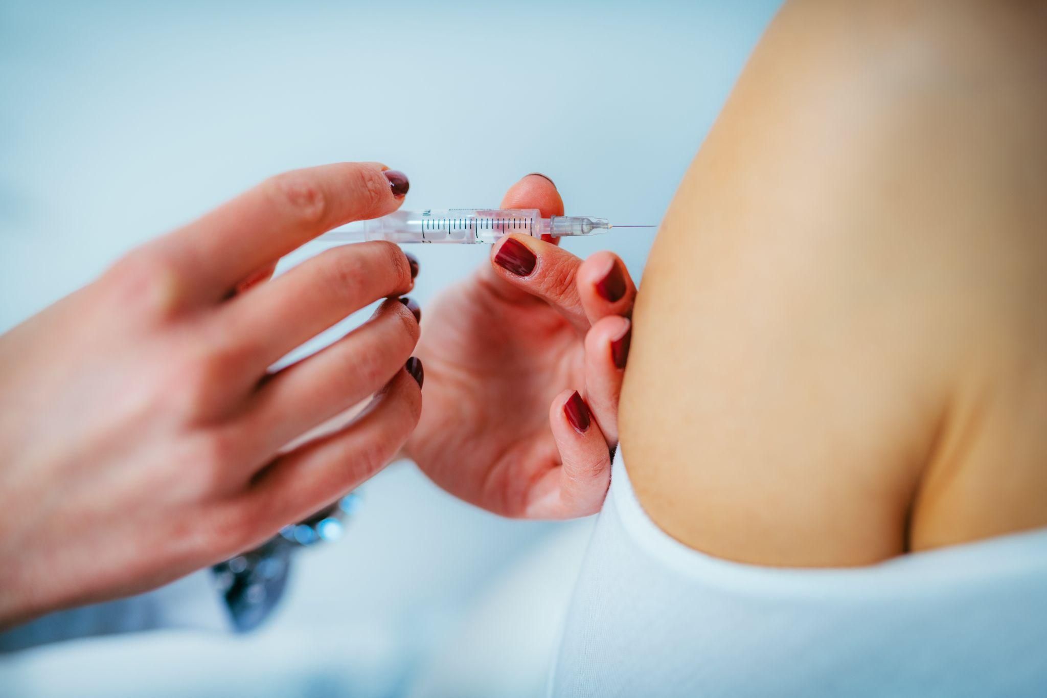 A healthcare professional administering antenatal steroids to a pregnant woman at risk of preterm birth.