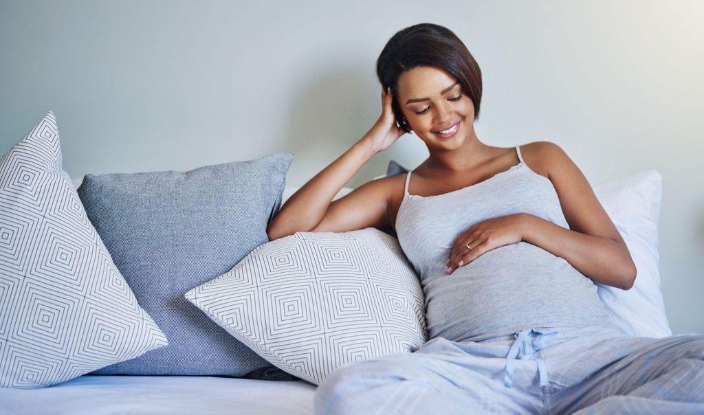 A pregnant woman relaxing, focusing on her baby’s movements.