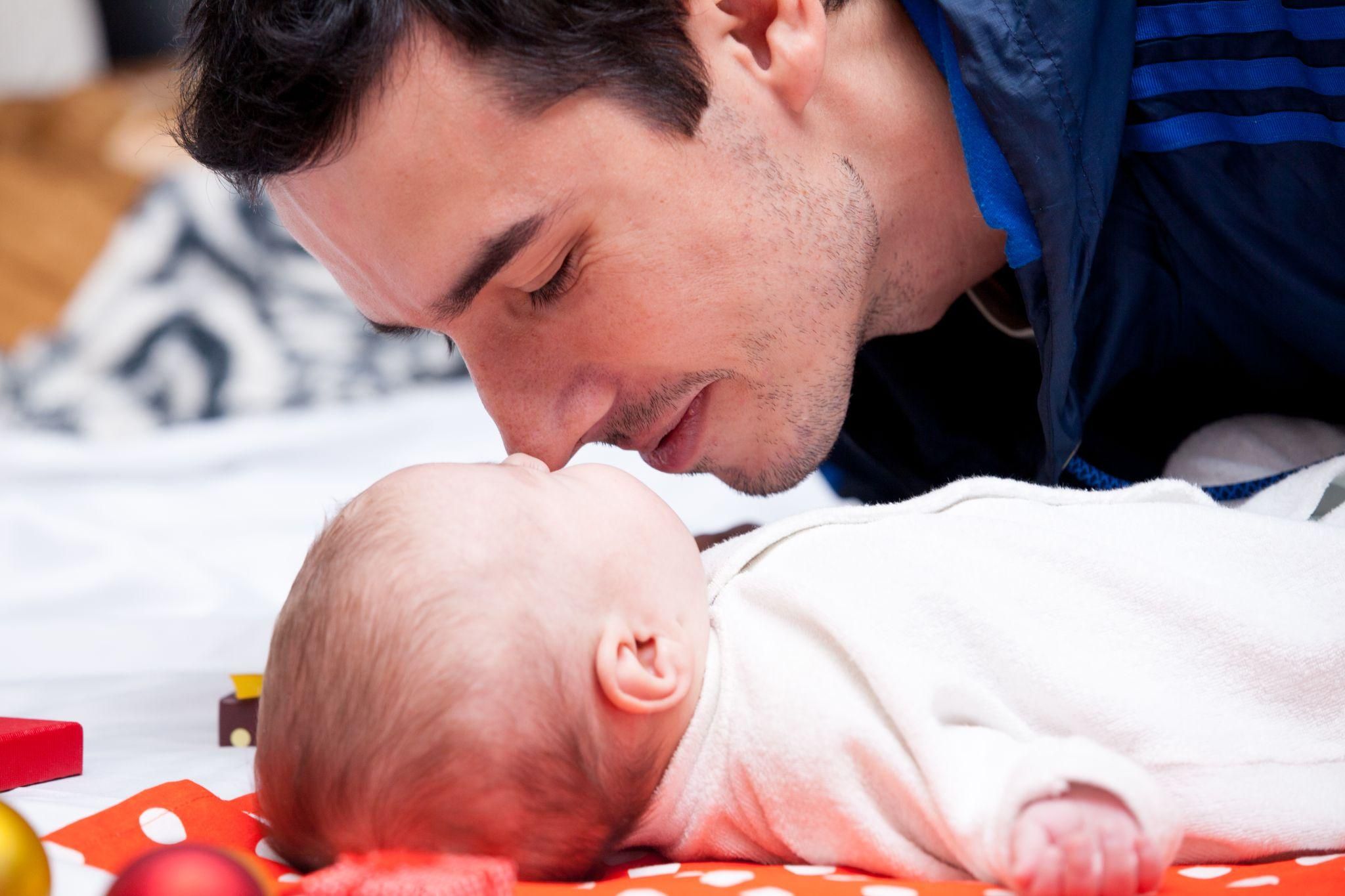 A father supporting his partner and bonding with his baby during the postpartum phase.