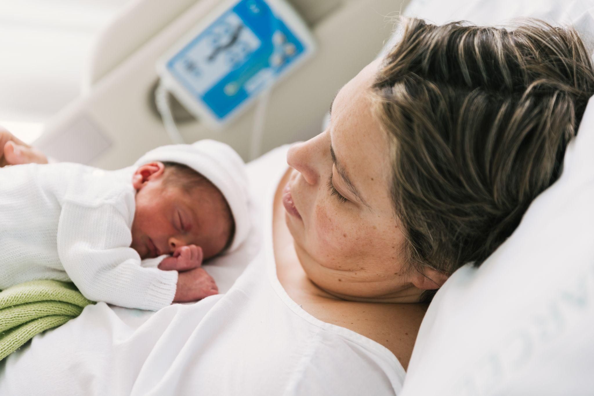 A parent comforting a fussy baby during the witching hour, using soothing techniques like swaddling.