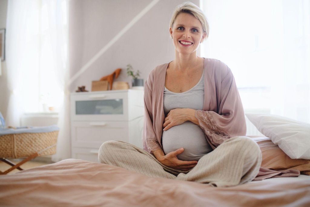 A happy pregnant woman outdoors, symbolising antenatal mental health and well-being.