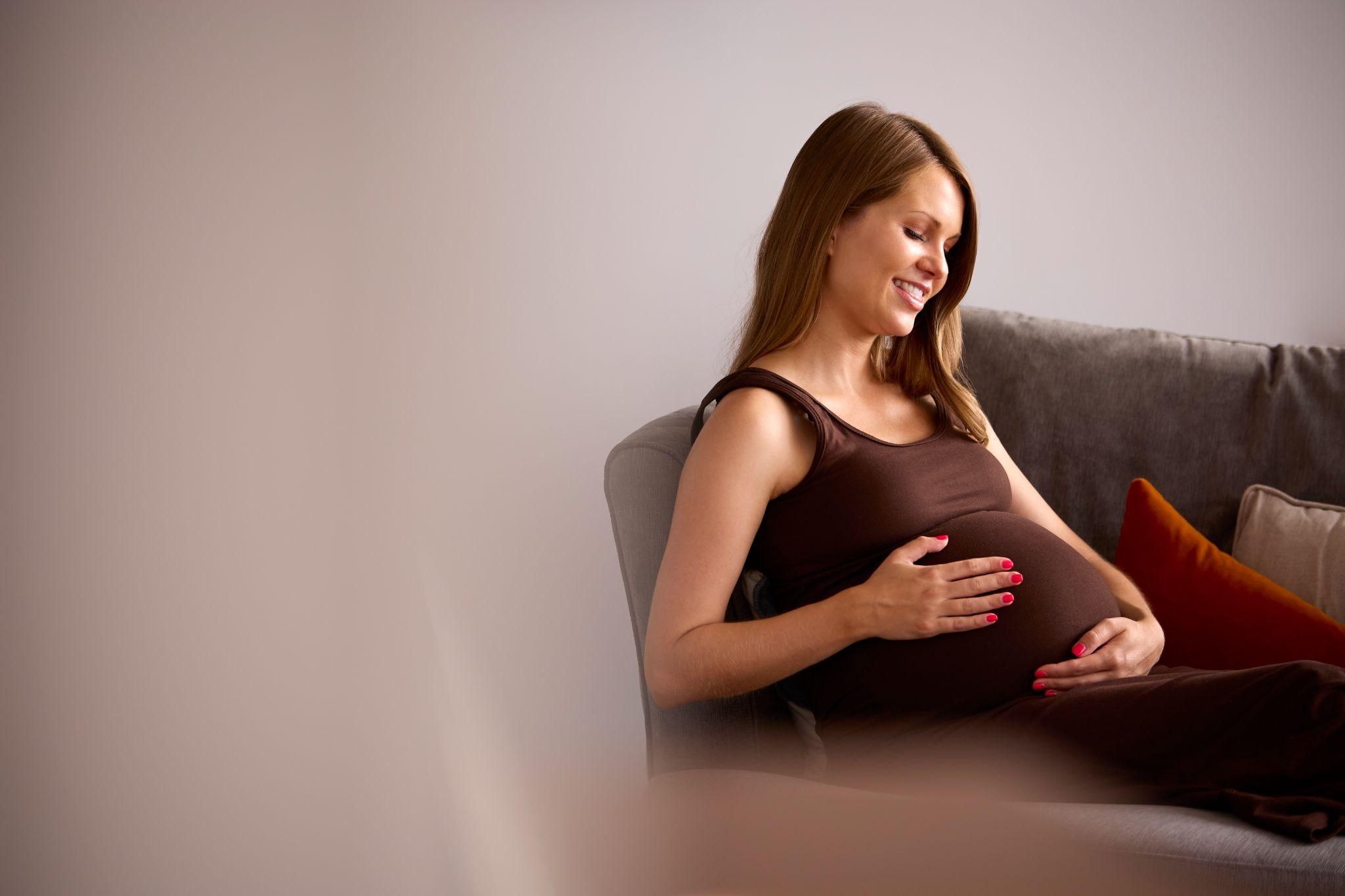 Pregnant woman at 36 weeks practising prenatal yoga, feeling calm and relaxed.