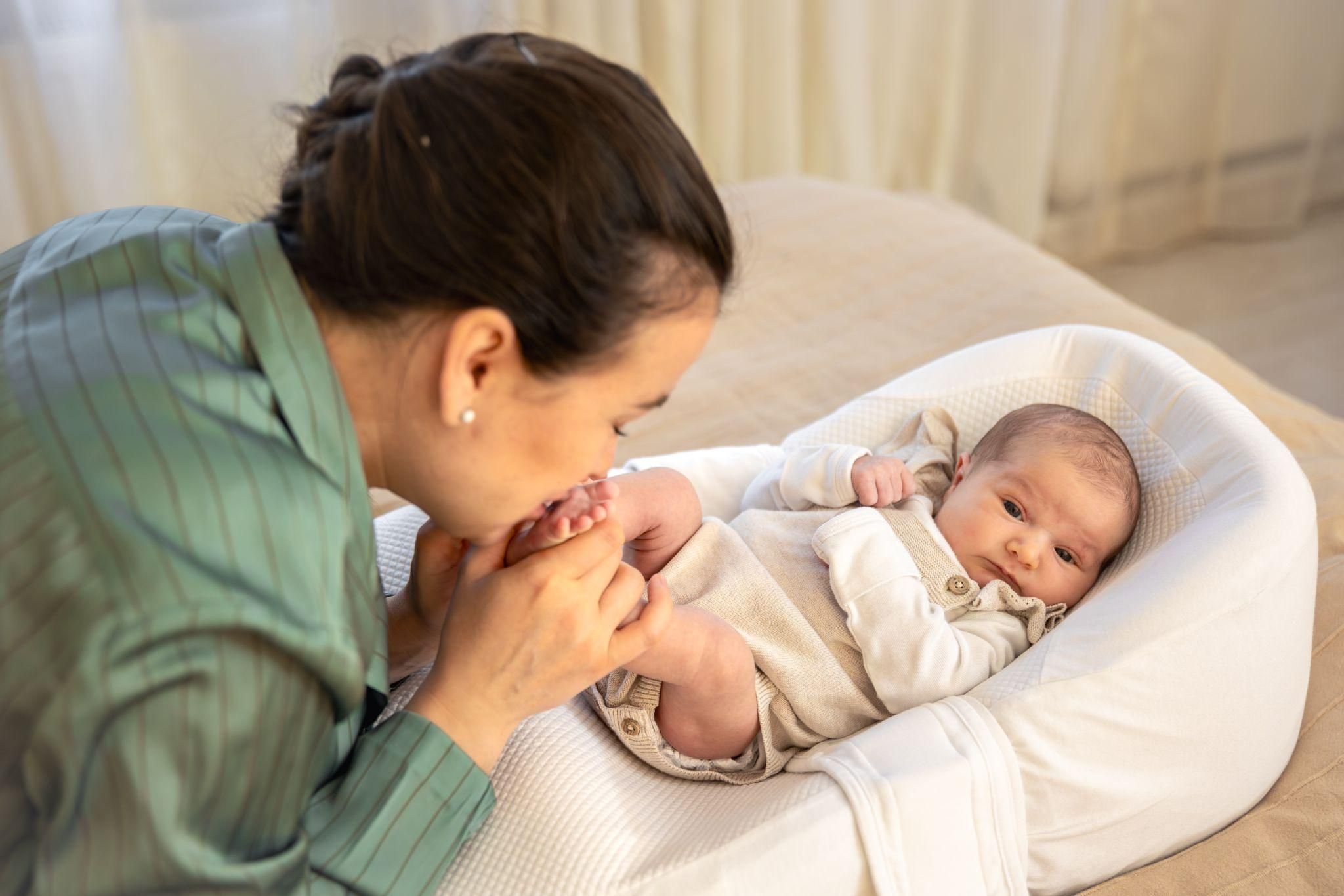 A mother cradling her newborn baby in a calming environment, both appearing relaxed.