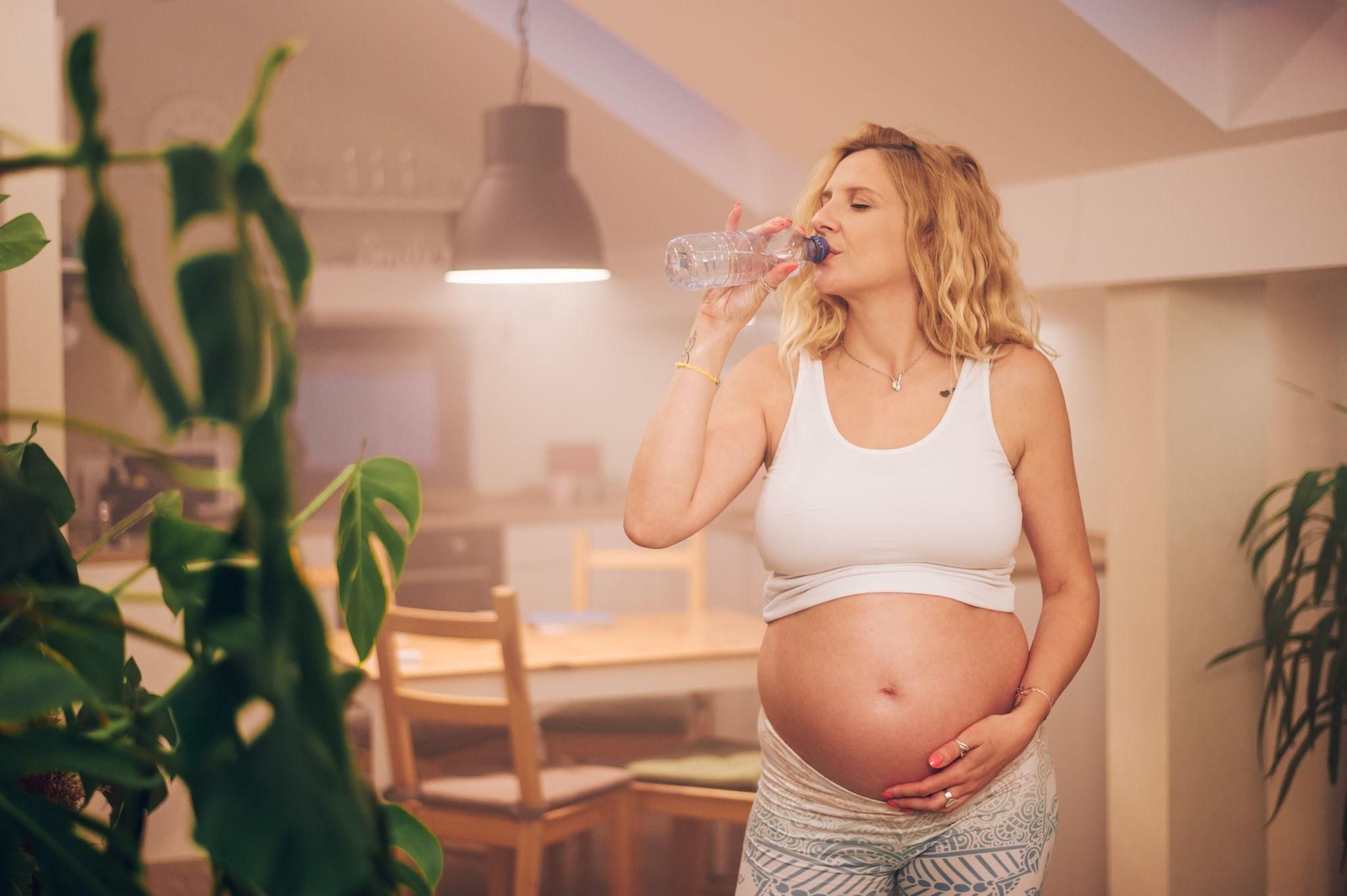 Pregnant woman staying hydrated as part of antenatal care and labour preparation.