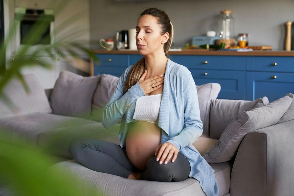 A pregnant woman practising breathing techniques during her labour preparation.